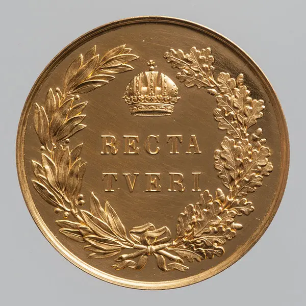 Die Abbildung zeigt eine goldene Medaille mit dem Inschrift