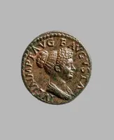 Eine antike Münze mit dem Profil eines weiblichen Kopfes. Die Darstellung zeigt eine Frau mit aufwändigem Haar und einem dekorativen Kleid. Um den Rand sind römische Schriftzeichen sichtbar, die den Namen oder Titel der abgebildeten Person anzeigen.