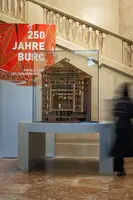 Modell eines historischen Gebäudes in einer Glasvitrine, präsentiert im Rahmen einer Ausstellung mit dem Titel 