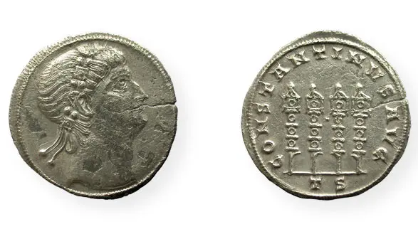 Die Abbildung zeigt eine römische Silbermünze mit dem Profil einer weiblichen Figur auf einer Seite. Auf der anderen Seite sind fünf Säulen abgebildet, die durch Linien verbunden sind, mit einer Inschrift darunter. Die Münze stammt aus der Antike.