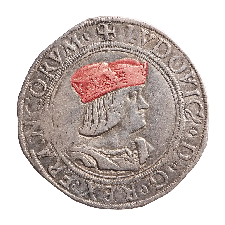 A silver coin features a profile of a man wearing a reddish crown. Surrounding the image is text with the name 