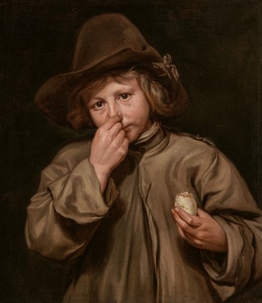 Ein Junge mit lockigem Haar trägt einen großen Hut und eine einfache, dreckige Jacke. Er hält ein Ei in der rechten Hand und hält mit der linken Hand seine Nase, als ob er einen schlechten Geruch wahrnimmt. Der Hintergrund ist dunkel und einfarbig.