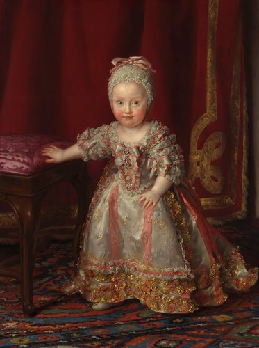 Ein kleines Mädchen in einem prunkvollen Kleid sitzt auf einer gepolsterten Bank. Sie hat blonde Haare, die mit einem Kopfband geschmückt sind, und schaut mit einem sanften Ausdruck in die Kamera. Der Hintergrund ist rot, mit goldenen Verzierungen.