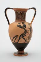 Eine griechische Amphore aus Ton mit einem verzierter Körper. Auf der Oberfläche sind künstlerische Darstellungen von Kämpfern und runden Schilden. Die Farbgestaltung umfasst ein kontrastierendes Schwarz und Orange, das typisch für antike griechische Keramik ist.