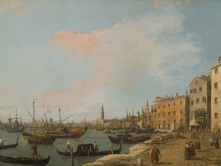 Eine Hafenansicht mit vielen Booten und Schiffen im Wasser. Am Ufer sind Gebäude sichtbar, und einige Menschen bewegen sich an der Promenade. Der Himmel ist blau mit einigen Wolken, und es gibt Turmspitzen von Kirchen und anderen Bauwerken im Hintergrund.