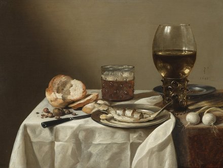 Stillleben mit einem Teller Fisch, einer Flasche Wein, einem Glas, Brot und einigen Nüssen. Auf einem Tisch liegt ein weißes Tischtuch, und im Hintergrund sind Zwiebeln und weiteres Gemüse sichtbar. Die Komposition vermittelt eine ruhige, häusliche Atmosphäre.