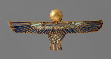 Ein schimmerndes ägyptisches Schmuckstück in Form eines Vogels mit weit ausgebreiteten Flügeln. Der Vogel hat einen goldenen Kopf und ist mit buntem Emaille in Blau und Grün verziert. Es symbolisiert Schutz und Kraft.