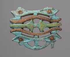 Ein bronzefarbenes, dekoratives Stück mit geometrischen Mustern und organischen Formen, das in verschiedenen Grüntönen patiniert ist. Es zeigt eine Kombination aus geschwungenen Linien und stilisierten Augenmotiven.