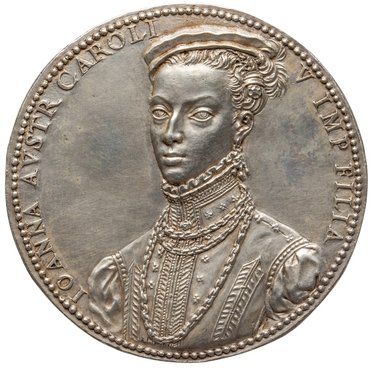 Eine Medaille zeigt ein Porträt einer Frau mit aufwendiger Kleidung und Frisur. Sie hat einen ernsten Gesichtsausdruck und trägt auffälligen Schmuck. Um das Porträt herum sind in lateinischer Schrift ihr Name und Titel eingraviert.