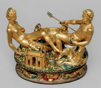 Eine goldene Skulptur zeigt zwei nackte mythologische Figuren, die auf einem kunstvoll gestalteten Sockel sitzen. Die Figuren sind von Tieren und Pflanzen umgeben, während eine der Figuren einen Dreizack hält. Im Hintergrund ist ein kleiner Tempel angedeutet.