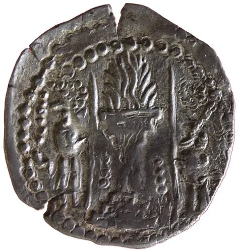 Die Abbildung zeigt eine zerbrochene Münze mit einer Darstellung von zwei Figuren, die neben einem lodernden Feuer stehen. Um das Feuer sind kreisförmige Muster angeordnet. Die Münze ist aus Metall und hat eine unregelmäßige Form.