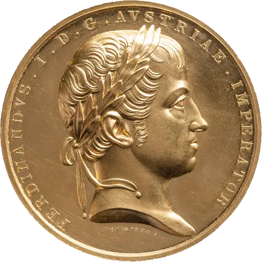 Die Abbildung zeigt eine goldene Medaille mit einem Seitenprofil von Ferdinand I. von Österreich. Er trägt einen Lorbeerkranz und hat kurze, lockige Haare. Der Rand der Medaille ist mit lateinischen Schriftzügen versehen, die seinen Namen und Titel angeben.