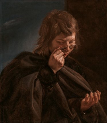 Eine nachdenkliche Person mit zerzausten Haaren hält eine Brille in der einen Hand und schaut auf ihre andere Hand. Sie trägt einen dunklen Umhang und hat einen konzentrierten Ausdruck. Der Hintergrund ist in dunklen, gedämpften Tönen gehalten.