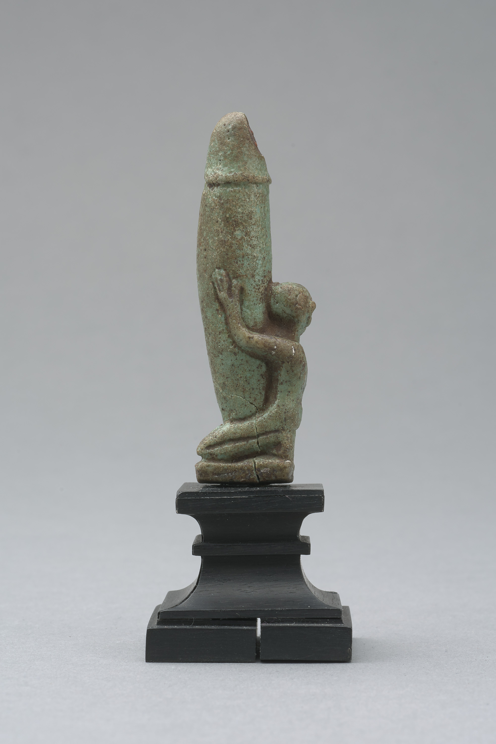 Figur eines knienden, nackten Mannes mit großem, aufgerichtetem Phallus