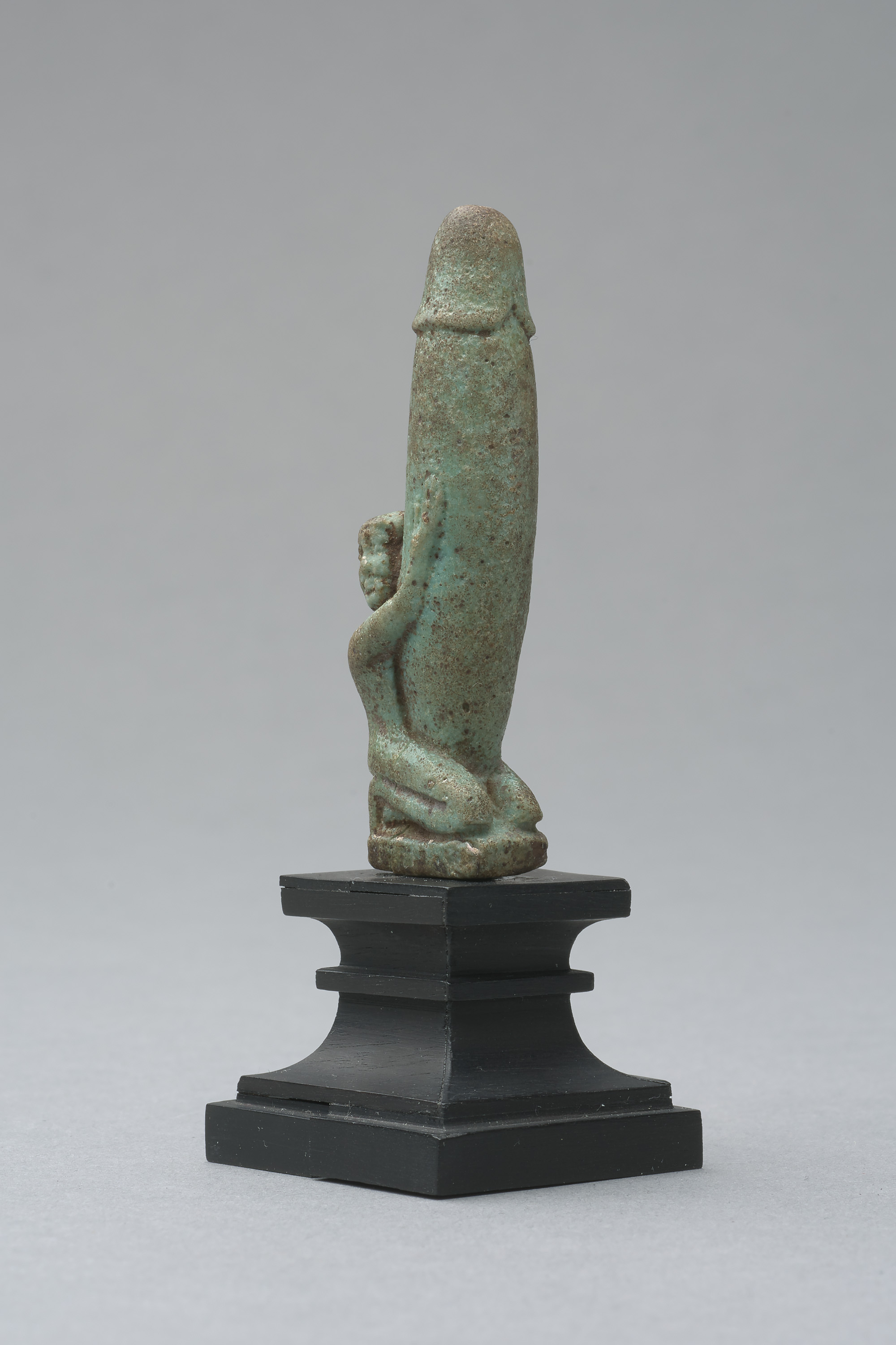 Figur eines knienden, nackten Mannes mit großem, aufgerichtetem Phallus