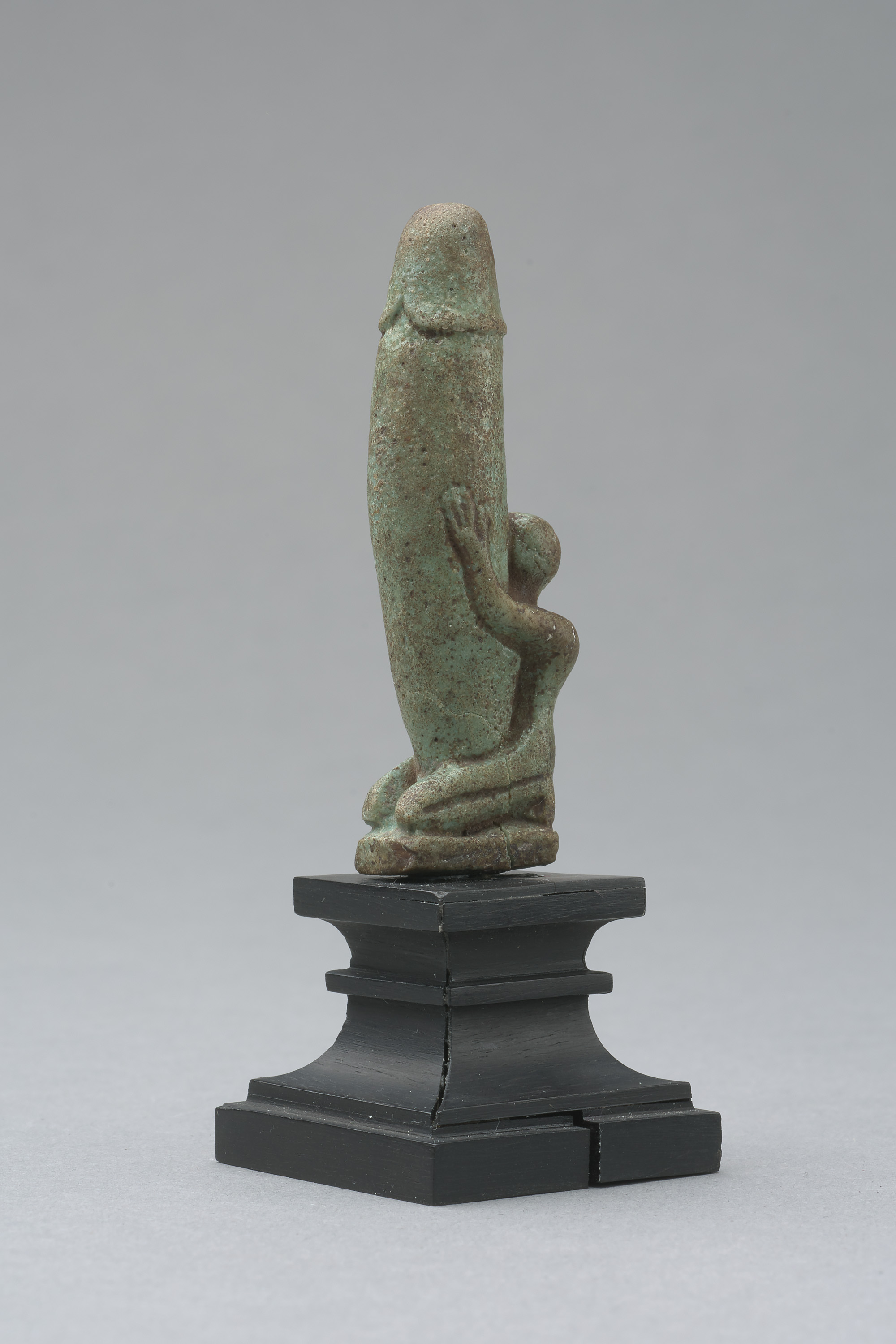 Figur eines knienden, nackten Mannes mit großem, aufgerichtetem Phallus