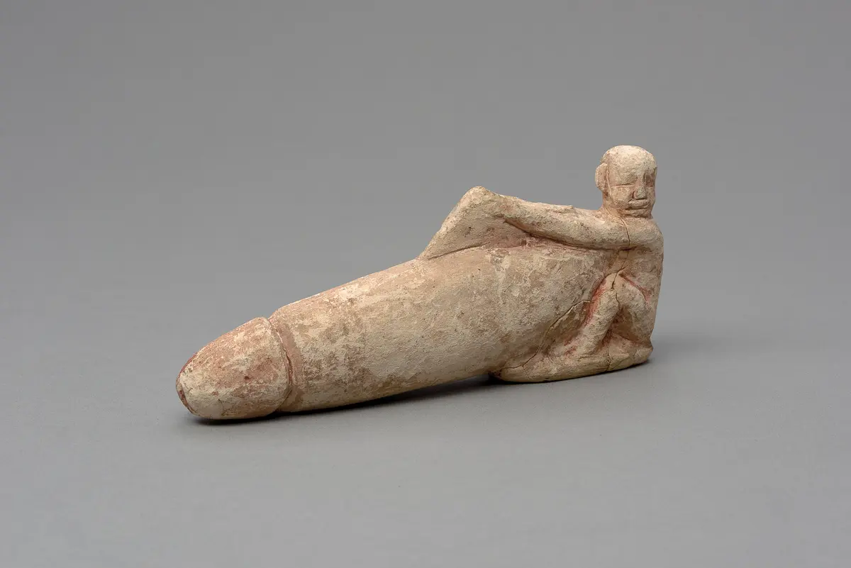 Hockender, nackter Mann mit übergroßem Phallus und Harfe
