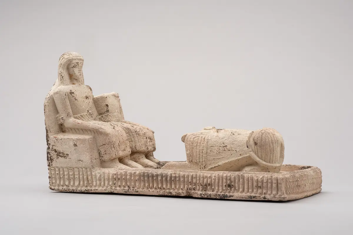 Figurengruppe: Zwei Männer vor einem Sphinx sitzend