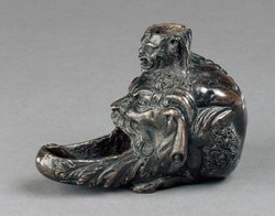 Öllampe in Gestalt eines hockenden Satyrs mit groteskem Maskeron zwischen den Knien