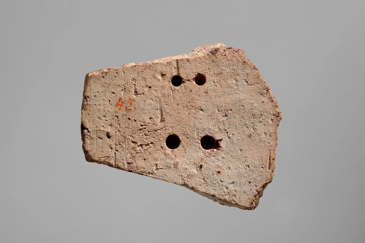 Fragment einer Aufsatzplatte(?) mit Darstellung von musizierenden Flügelfrauen in Ranken. Flügelfrau mit Kithara