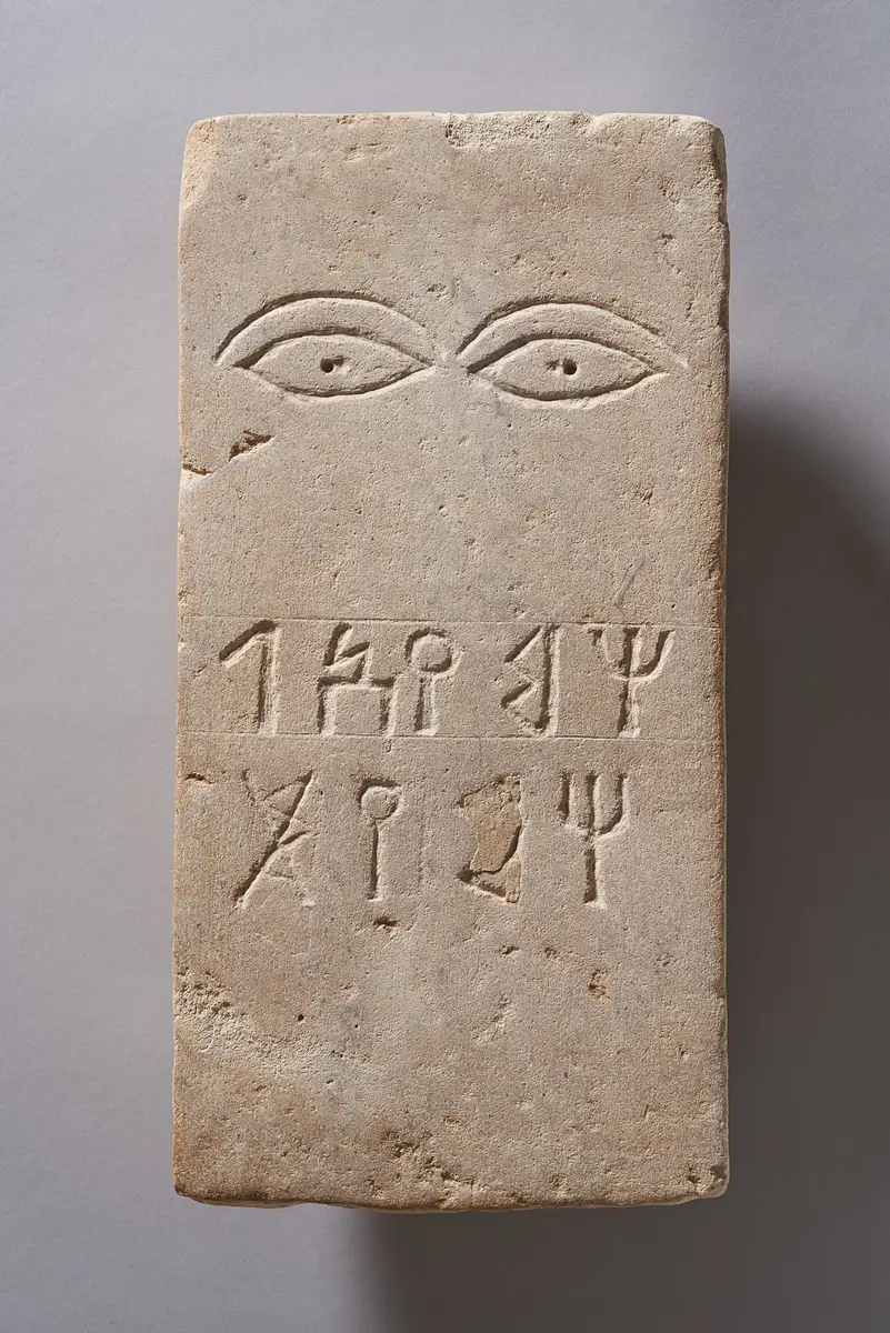Grabstein mit Augen und Inschrift
