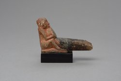 Hockender, nackter Mann mit übergroßem Phallus, eine Stele haltend