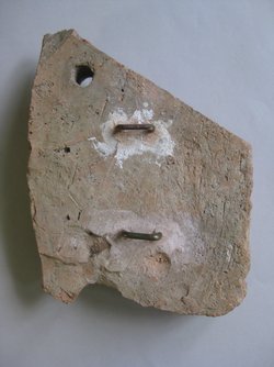 Fragment einer Verkleidungsplatte: Zierstreifen mit Maskenfries