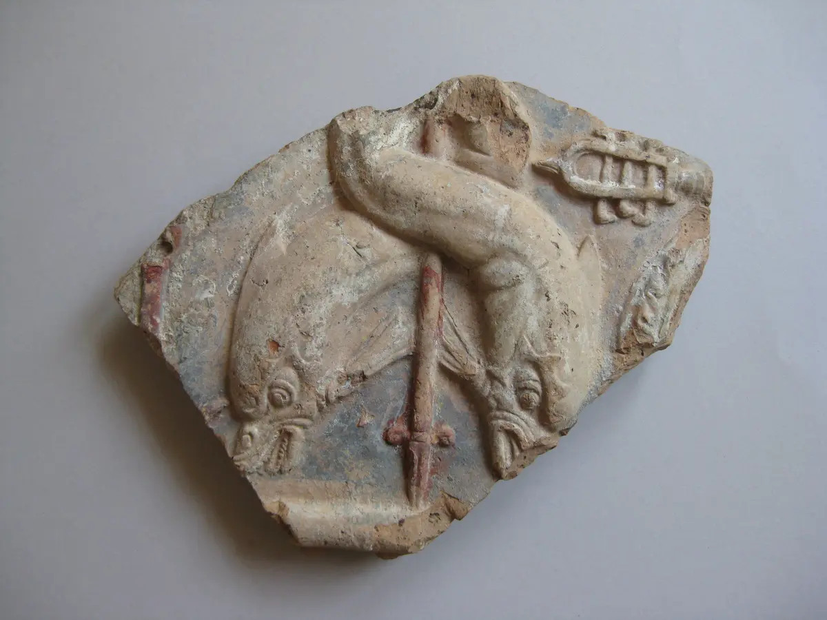 Fragment einer Aufsatzplatte mit Darstellung einer Meermedusa: Delphinpaar um Dreizackschaft