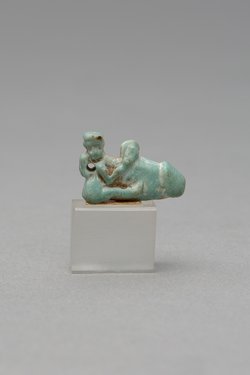 Mit ausgestreckten Beinen sitzender, nackter Mann mit übergroßem Phallus und Röhrentrommel