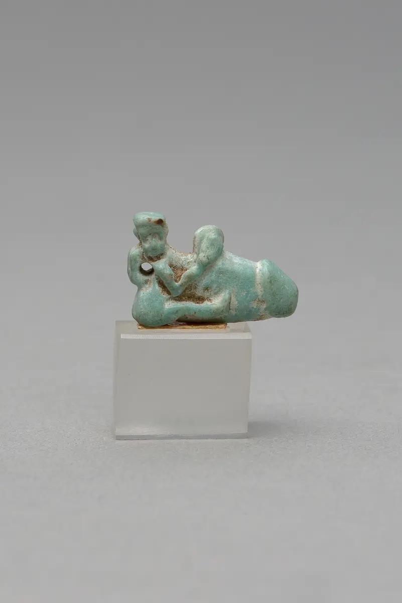 Mit ausgestreckten Beinen sitzender, nackter Mann mit übergroßem Phallus und Röhrentrommel