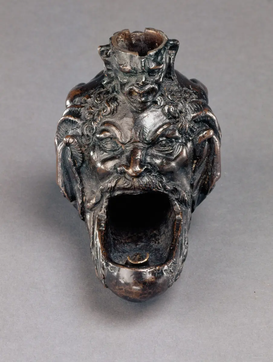Öllampe in Gestalt eines hockenden Satyrs mit groteskem Maskeron zwischen den Knien