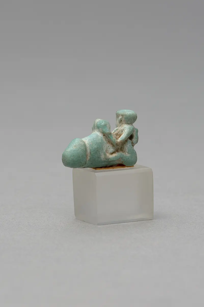 Mit ausgestreckten Beinen sitzender, nackter Mann mit übergroßem Phallus und Röhrentrommel