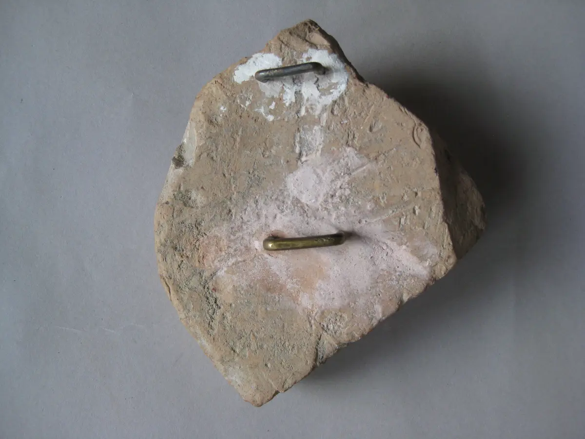 Fragment einer Krönung mit Köpfen in Bändern in Form einer liegenden Acht: Bärtiger Kopf