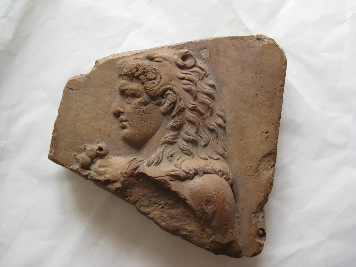 Fragment vom rechten Rand einer Verkleidungsplatte mit Dreifußstreit: Kopf des Herakles