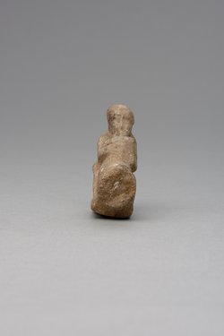 Hockender, nackter Mann, über seinem Phallus eine Stele haltend, fragmentiert