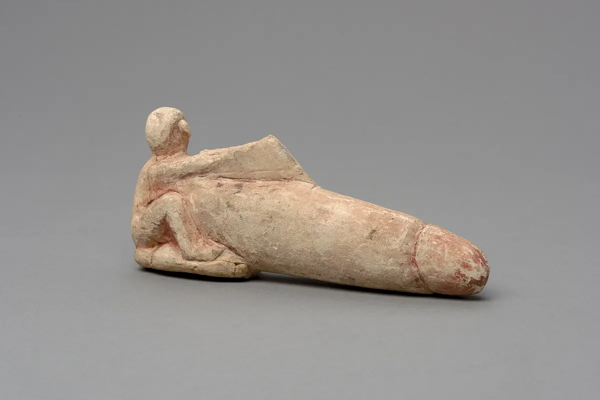 Hockender, nackter Mann mit übergroßem Phallus und Harfe