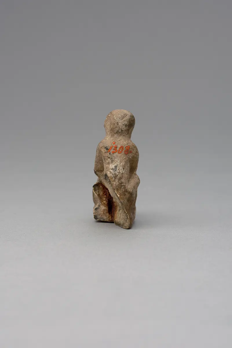 Hockender, nackter Mann, über seinem Phallus eine Stele haltend, fragmentiert