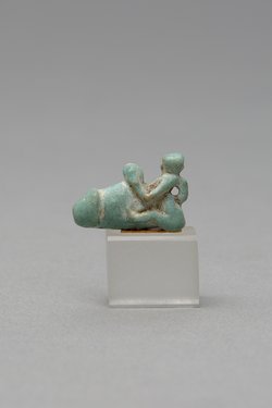 Mit ausgestreckten Beinen sitzender, nackter Mann mit übergroßem Phallus und Röhrentrommel