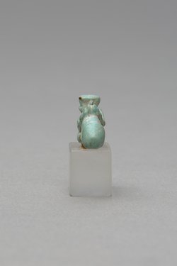 Mit ausgestreckten Beinen sitzender, nackter Mann mit übergroßem Phallus und Röhrentrommel
