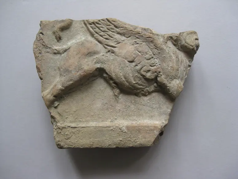 Fragment aus dem linken Teil einer Sima(?) mit Darstellung von Sphingen zu Seiten einer männlichen Büste: Geflügelter männlicher Sphinx