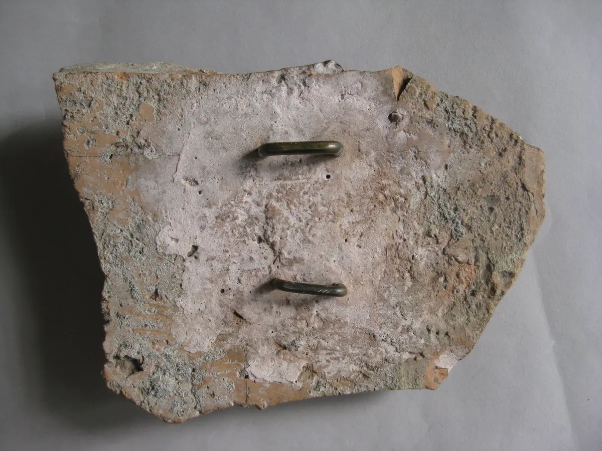 Fragment einer Krönung(?) mit Masken in schlangenförmig gewundenen Bändern: Gorgoneion