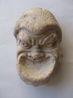 Fragment einer Krönung mit Theatermasken im Bogenfries: Theatermaske