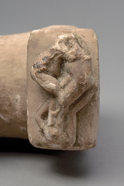 Glans (Eichel), darauf ein Bett, in dem sich ein Paar gegenüber liegt; Köpfe fehlen
