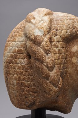 Statuenkopf eines Mannes mit Seitenzopf
