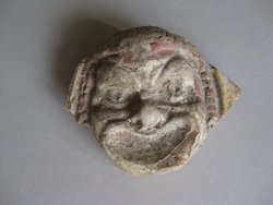 Fragment einer Krönung mit Theatermasken im Bogenfries: Maske