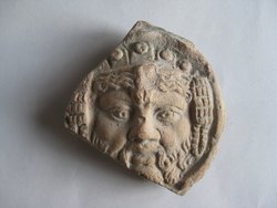 Fragment einer Krönung mit Köpfen in Bändern in Form einer liegenden Acht: Bärtiger Kopf