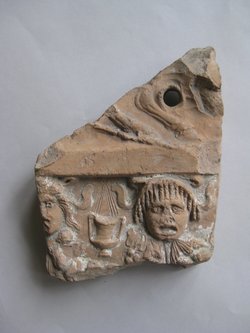 Fragment einer Verkleidungsplatte: Zierstreifen mit Maskenfries